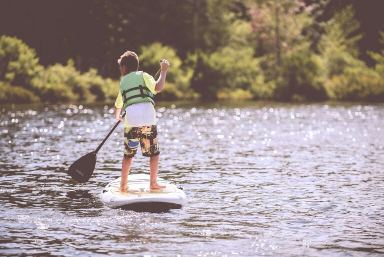 Older adult paddling a kayak on calm water