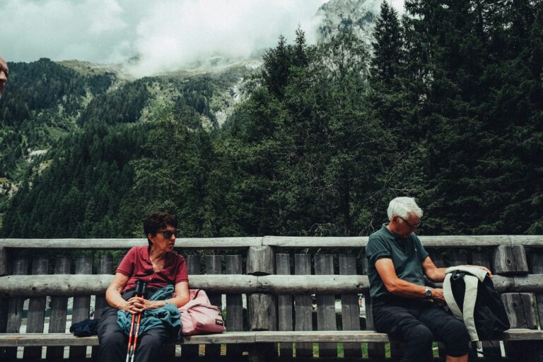 Senior hikers resting in front of mountain scenery