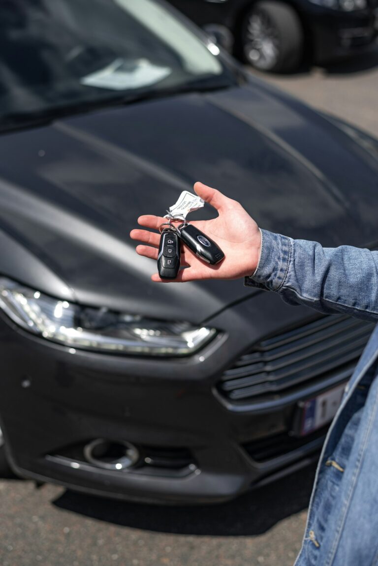 Older adult holding car keys near a vehicle